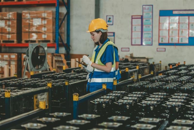 Worker inspecting finished parts in warehouse